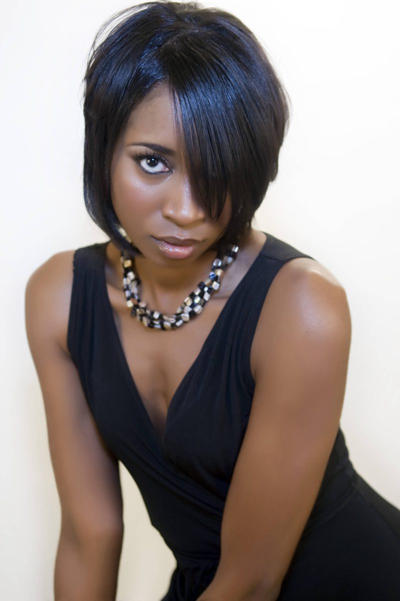 Studio portrait of a woman in a black dress and statement necklace